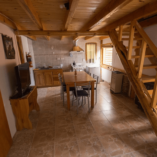 Interior rústico de cabaña con comedor y cocina en Cabañas Shautiau
